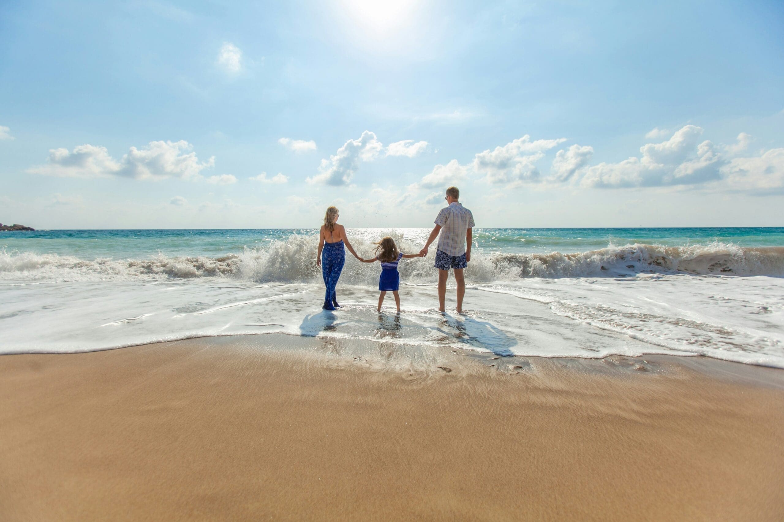 a family entering the water on the beach