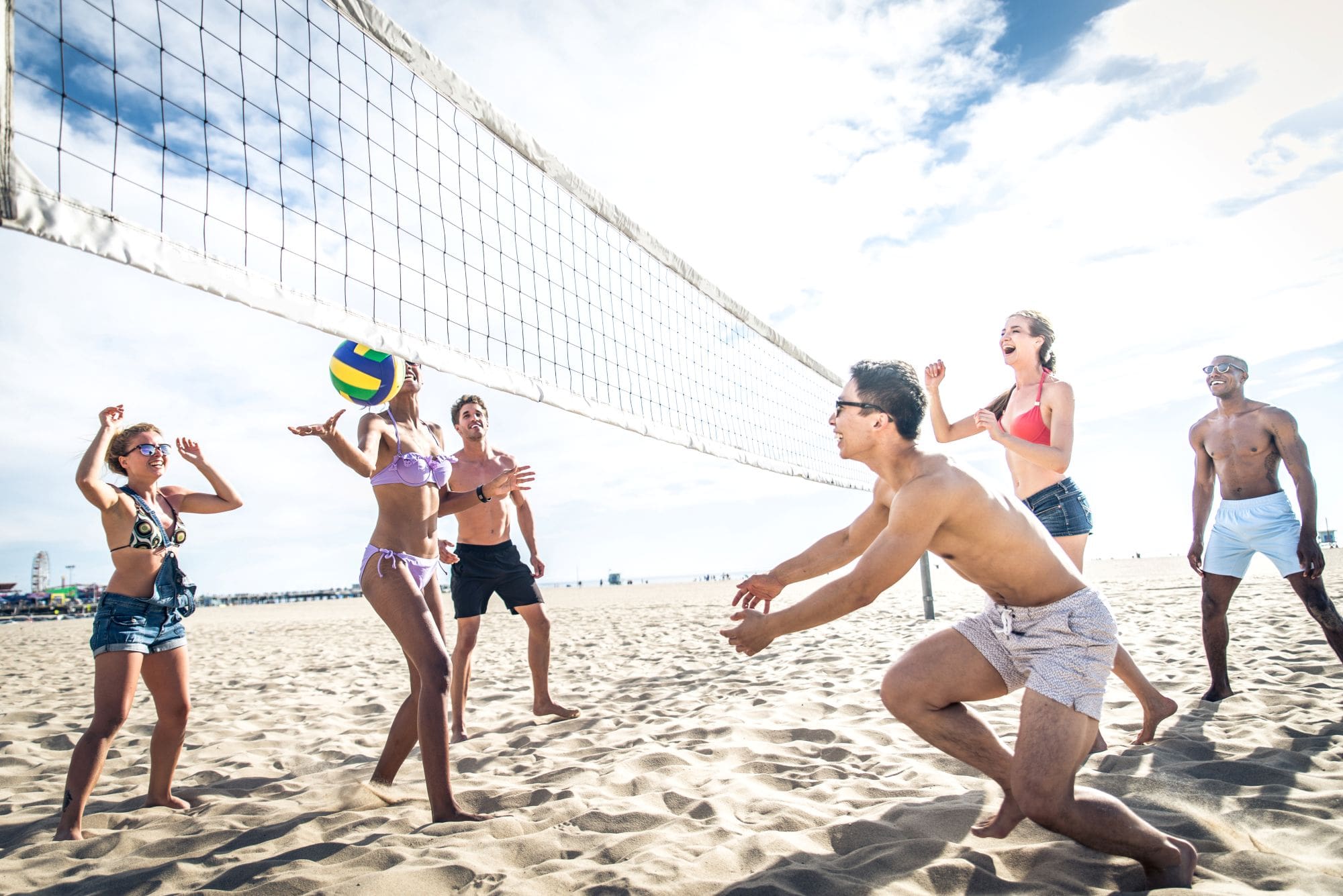 friends playing volleyball at the beach